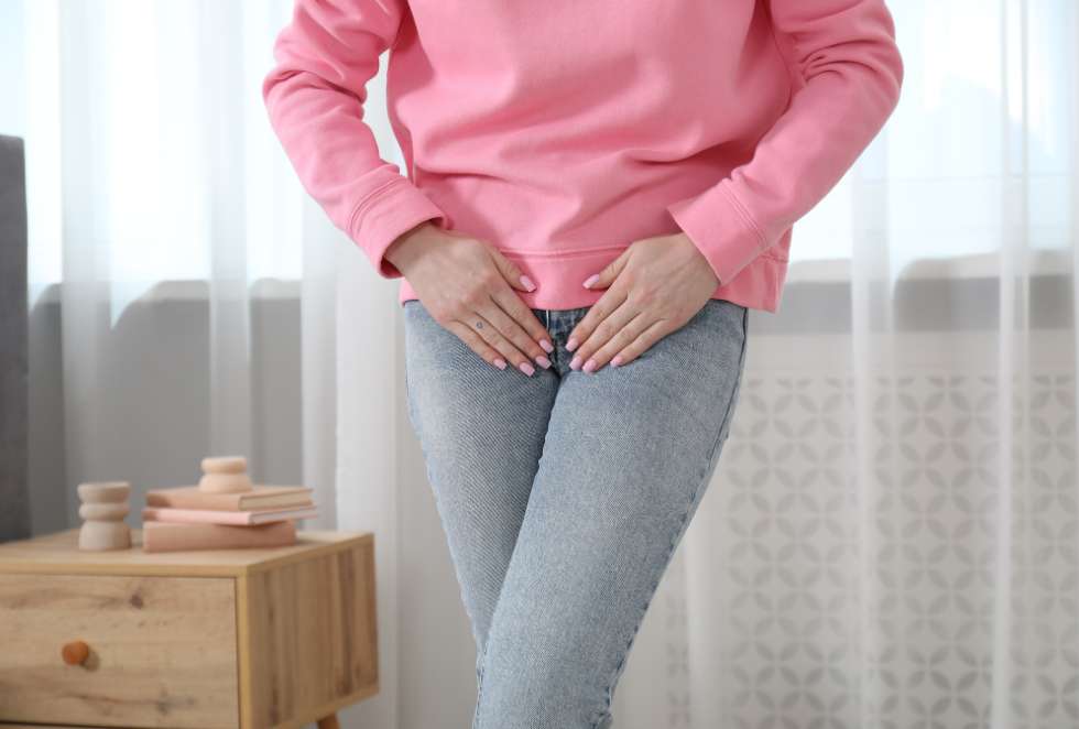 Woman standing with legs crossed and hands near pelvic area for Health Builders stress incontinence treatment options in Annandale
